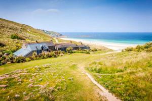 森嫩Basking Shark, Studio Cottage With Superb Sea Views By Beach的海滩旁小山上的房屋