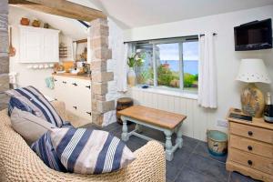 森嫩Basking Shark, Studio Cottage With Superb Sea Views By Beach的带沙发、桌子和窗户的客厅