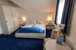 富尔普梅斯Hotel Garni Hubertus-Nostalgie & Charme的一间卧室配有一张大床和一把椅子