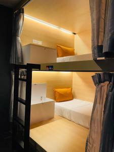 普吉镇Rabbitel Phuket的客房设有两张双层床和梯子