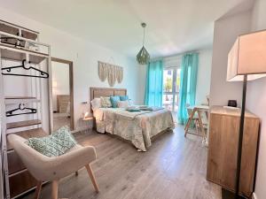莫特里尔Aguacate Beach Apartamentos Playa Granada的一间卧室配有一张床、一把椅子和镜子