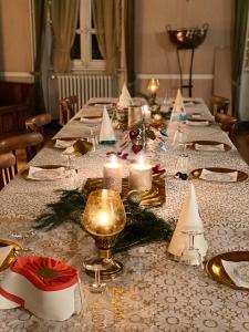 GiatHôtel de famille L.F.M.A.L.的一张带蜡烛和圣诞装饰的长桌