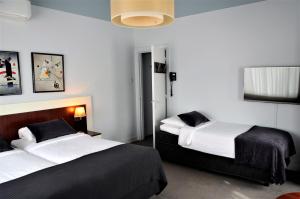 奈梅亨阿波罗酒店的一间卧室设有两张床,墙上配有电视。