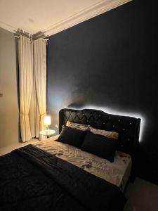巴西富地Majestic Homestay - Pasir Puteh的一间卧室配有一张黑色墙壁的床