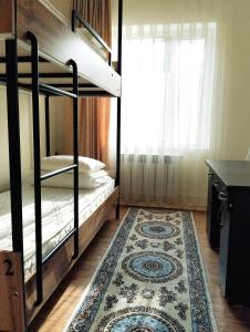 比什凯克Salma Capsule Hostel的一间设有两张双层床和地毯的房间