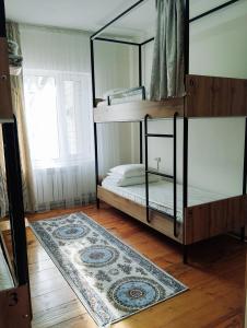 比什凯克Salma Capsule Hostel的卧室配有两张双层床和地毯。