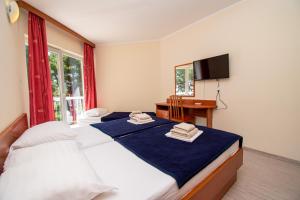 普拉Centinera Resort的一间卧室配有两张床、一张桌子和一台电视。
