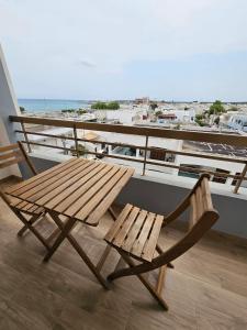新福卡Casa dei Nodi的海滩阳台的木桌和椅子