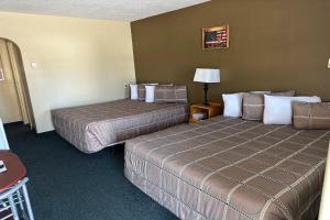 默多Love Hotels Murdo on Interstate 90的酒店客房,设有两张床和一盏灯