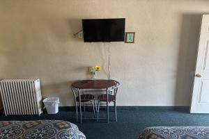 默多Love Hotels Murdo on Interstate 90的一间设有桌子和墙上电视的房间