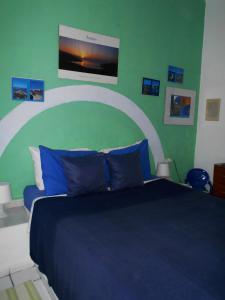 马拉松坎博斯Meltemia Studios的一间卧室设有蓝色的床和绿色的墙壁