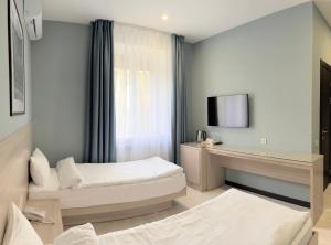 阿拉木图Resident Hotel Gogol的酒店客房设有两张床和电视。
