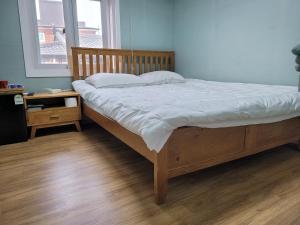 晋州市Songil Guesthouse的卧室内的一张带白色床单和枕头的床