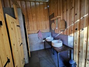 Stari Trg pri LožuDormitory and wooden house Beli gaber的浴室设有木墙和两个水槽。