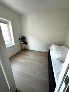 桑内斯Nydelig perle rett ved fjorden的一间卧室配有一张床,铺有木地板