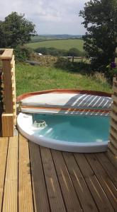 布德Ivy Rose Cabin with private hot tub的木甲板上的小船