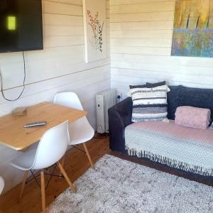 布德Ivy Rose Cabin with private hot tub的客房设有书桌、床、桌子和椅子。