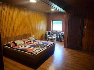 Mlynky Apartmány GUGEL MLYNKY的卧室配有一张床铺,位于带木墙的房间内