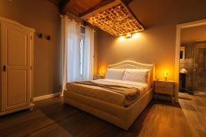 萨卢佐Agriturismo Agli ulivi的一间卧室设有一张大床和一个窗户。