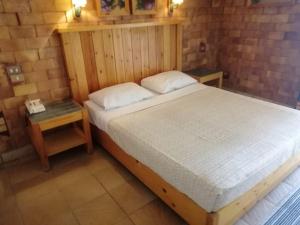 塔巴Tobya Village Hotel的一间卧室配有一张大床和一个床头柜