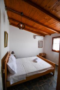 科罗尼Anastasios House的木天花板的客房内的一张床位