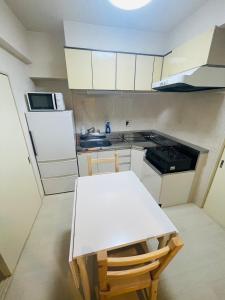 KusugaurachōASUKA HINODECHO ｌ日の出町的小厨房配有白色桌子和水槽