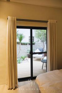 高雄瀉湖-私人公寓 The Lagoon-Mediterranean vibe vacation house的卧室设有滑动玻璃门,可通往庭院。