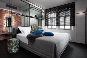 罗滕堡米特迈尔阿尔特伊格酒店的卧室配有带蓝色枕头的大型白色床