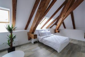 卢戈日Palatul Lugoj的卧室拥有白色的墙壁和木梁。
