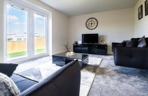 赫尔Beautiful Home in Kingston-Upon-Hull的客厅配有沙发和墙上的时钟