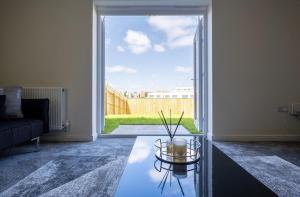 赫尔Beautiful Home in Kingston-Upon-Hull的带沙发和玻璃桌的客厅