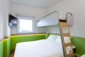 万隆万隆亚非宜必思快捷酒店的一间卧室配有带梯子和窗户的双层床