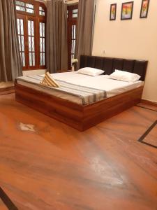 AyodhyaPAARIJAAT Homestay & Guesthouse的铺有木地板的客房内一张大床