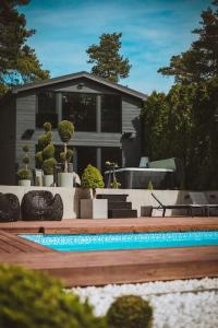 PriedkalneBLACK HOUSE - premium holiday guest house的庭院中带游泳池的房子
