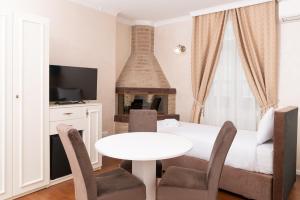 萨拉热窝Ornament Hotel的客厅配有桌子和壁炉