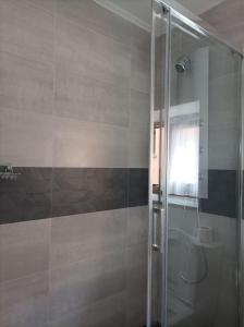 VillarCasa rural en Sariego的带淋浴的浴室和玻璃门