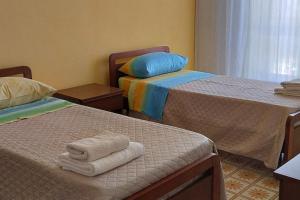 帕埃斯图姆Residenza dal Barone的一间设有两张床铺和毛巾的房间