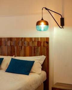 夏卡Domus Maris Relais Boutique Hotel的一间卧室配有一张带木制床头板和灯的床。