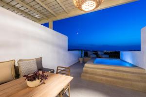 帕罗斯岛Sersi Paros Villas & Suites的客厅设有桌子和游泳池