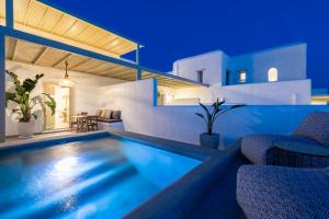 帕罗斯岛Sersi Paros Villas & Suites的夜间带游泳池的别墅