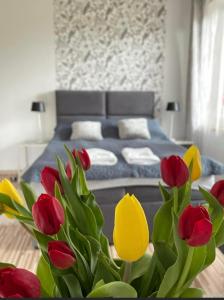 韦茨泽基斯韦斯基Villa Marzenie Pokój 2 osobowy的一间卧室配有一张红色和黄色郁金香床
