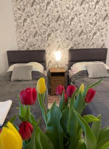韦茨泽基斯韦斯基Villa Marzenie Pokój 2 osobowy的一间卧室设有两张红色和黄色郁金香床。