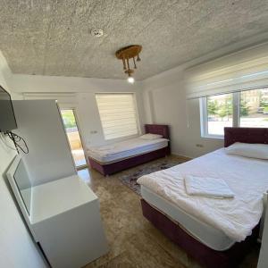 于尔居普KAPADOKYA DELUXE APART的一间卧室设有两张床和窗户。
