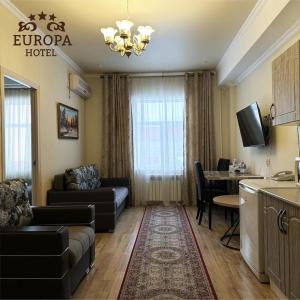 乌拉尔斯克Europa Hotel的带沙发和桌子的客厅以及厨房。