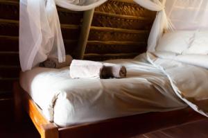 伊尼扬巴内Singila Ocean Lodge的两张带白色床单和毛巾的床