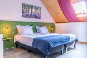 Grubbenvorst赫伯格德林德户夫酒店的一间卧室配有一张带绿色墙壁的床