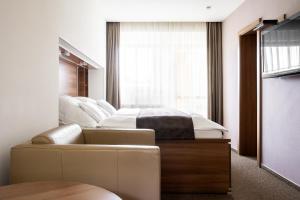 斯塔利斯莫克维克塔特拉司泊特匝姆帕膳食公寓的一间卧室配有一张床、一张沙发和一个窗口