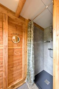 HavelangeLa Yourte de la Ferme Froidefontaine的配有木墙的客房内的淋浴