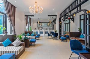 洞海Rex Quang Binh Hotel的客厅配有蓝色椅子和吊灯。