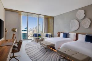 迪拜The St. Regis Downtown Dubai的酒店客房设有两张床和大窗户。